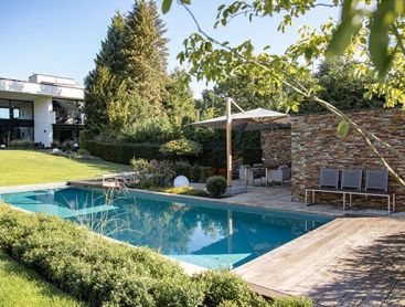 Ein Haus mit einem natuerlichen Pool und einer Terrasse im modernen Stil